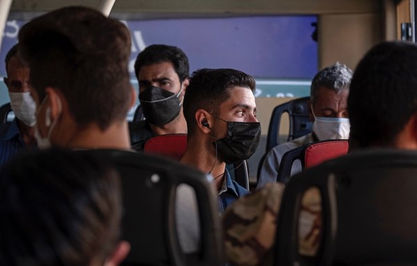 إيرانيون يستقلون حافلة نقل في طهران يوم 28 أيار/مايو، وهم يضعون كمامات في ظل انتشار جائحة كوفيد-19.ولا تزال اللقاحات المضادة لفيروس كورونا غير متوفرة لغالبية المواطنين. [وكالة الصحافة الفرنسية]