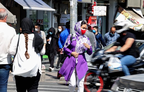 إيرانيون في ساحة انقلاب في وسط طهران يوم 16 أيار/مايو، وهم يضعون كمامات في ظل انتشار جائحة فيروس كورونا. ولم تتمكن غالبية الإيرانيين من الحصول على اللقاحات المضادة للفيروس. [عطا كيناري/وكالة الصحافة الفرنسية]