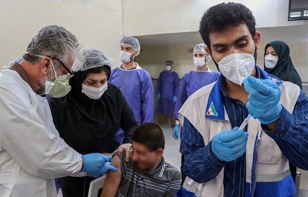 یک مرد جوان در ایران واکسن دریافت می‌ کند. بیماری کووید ۱۹ همچنان شیوع بالایی دارد چرا که فرآیند واکسیناسیون با سرعت بسیار کمی پیش می‌ رود. [خبرگزاری فارس]