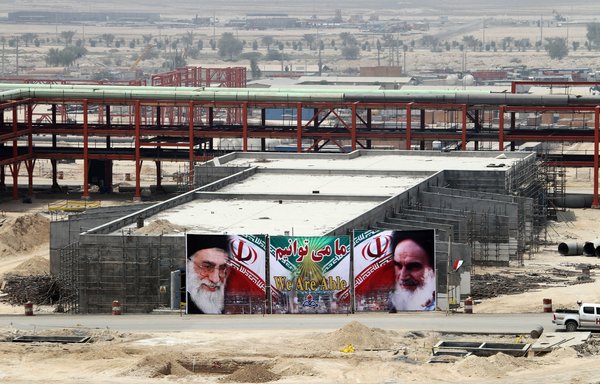 A huge banner bearing portraits of Iranian leader Ali Khamenei and his predecessor Rouhollah Khomeini is seen on a building being constructed at South Pars gas field in Asaluyeh in this file photo from July 19, 2010. [Atta Kenare/AFP]