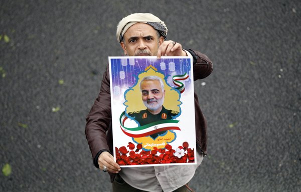 A supporter of the Houthis holds a poster of the late IRGC Quds Force commander Qassem Soleimani during a demonstration in Sanaa on January 6, 2020. [Mohammed Huwais/AFP]
