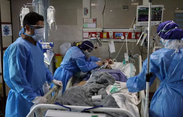 مسعفون يعالجون مريضا من كوفيد-19 في جناح مستشفى في محافظة سيستان وبلوشستان الإيرانية في حزيران/يونيو الماضي. [إيرنا]