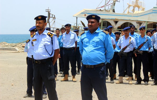 Members of the Yemeni coast guard stand at attention during a handing over ceremony as the Houthis withdraw from the Red Sea port of Saleef in al-Hodeidah province on May 11, 2019. [AFP]