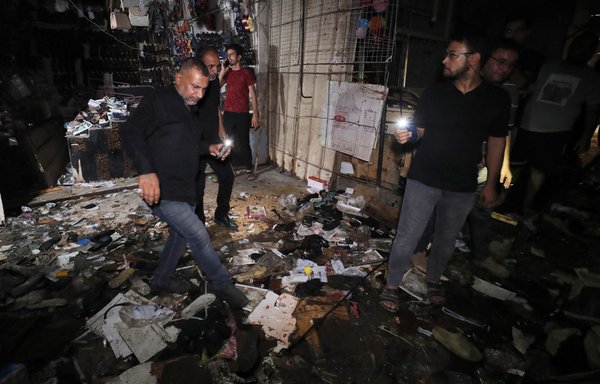 Iraqis inspect the site of an explosion at a market in Baghdad's Sadr City on July 19. At least 36 people were killed, including women and children, in an attack claimed by ISIS. [Ahmad al-Rubaye/AFP]