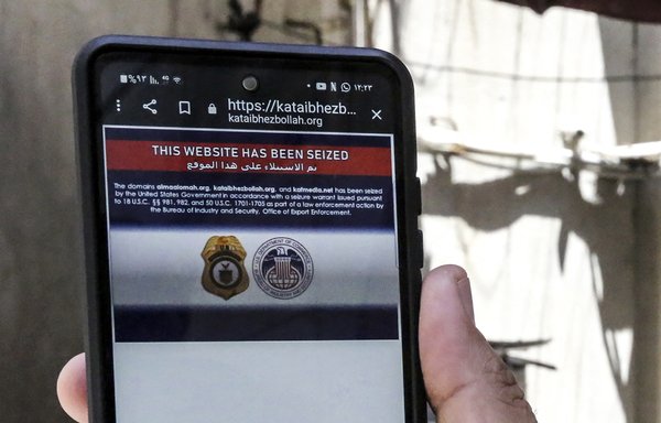 A man shows the error message on a Kataib Hizbullah website on his mobile phone in Baghdad on June 23. The US Justice Department said it had seized 33 Iranian government-controlled media websites, as well as three of Kataib Hizbullah, which it said were hosted on US-owned domains in violation of sanctions. [Sabah Arar/AFP]