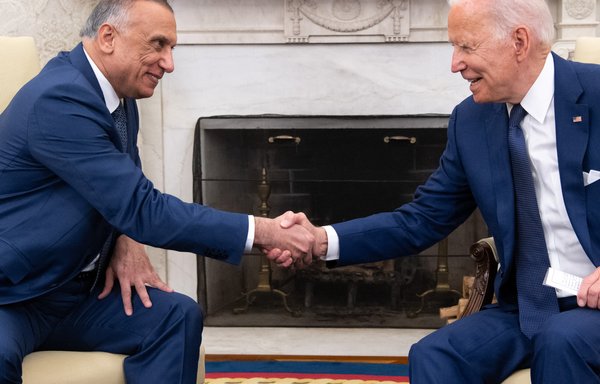 US President Joe Biden shakes hands with Iraqi Prime Minister Mustafa Kadhemi in the Oval Office of the White House in Washington, DC on July 26. [Saul Loeb/AFP]