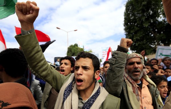 Supporters of the Iran-backed Houthis pump their fists during a rally in the Yemeni city of Sanaa on May 7. [Mohammed Huwais/AFP]
