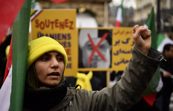 A protester raises her fist during a January 5, 2018, demonstration in France in support of the Iranian people amid a wave of protests spreading throughout Iran. [Christophe Simon/AFP]