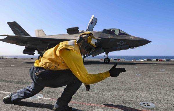 A US Navy sailor signals to an F-35B Lightning II as it takes off from the USS Makin Island in the Indian Ocean January 12. [US Navy]