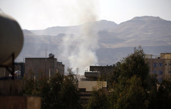 Smoke billows behind a building in Sanaa on December 2, 2017, during clashes between the Houthis and supporters of Yemeni ex-president Ali Abdullah Saleh, days before Saleh was killed. [Mohammed Huwais/AFP]