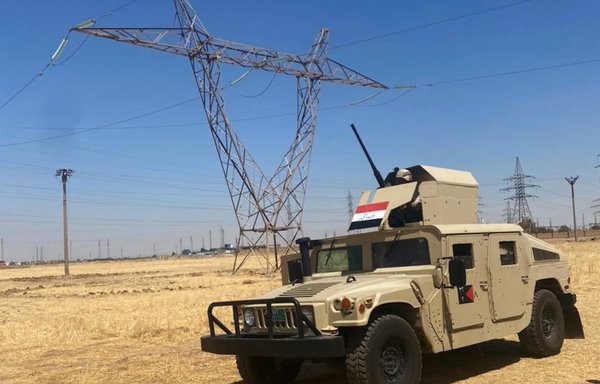 مركبة تابعة للجيش العراقي تظهر بالقرب من أحد أبراج الطاقة الكهربائية في هذه الصورة التي نشرت يوم 1 آب/أغسطس. [وزارة الدفاع العراقية]