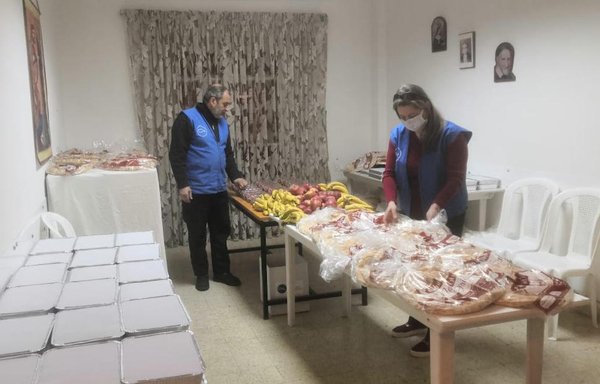 Volunteers prepare food to distribute to needy families as part of a non-sectarian, private initiative in Jounieh. [Rim Boueiz]