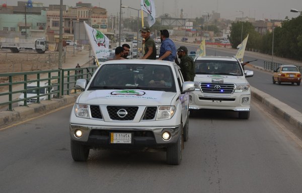 Members of the Asaib Ahl al-Haq militia, which is accused of committing sectarian killings and causing unrest in Iraq and the region, parade through the streets of Iraq in an undated photo. [Asaib al-Diwaniyah]