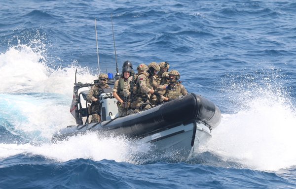 Royal Navy and US Navy sailors operate a rigid hull inflatable boat during multilateral air operations in support of a maritime surface warfare (AOMSW) exercise in the Arabian Gulf, July 21. [US Coast Guard]