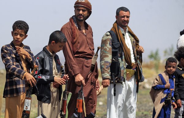 Armed Yemeni children and fighters loyal to the Iran-backed Houthis rally in Sanaa on May 20. [Mohammed Huwais/AFP]
