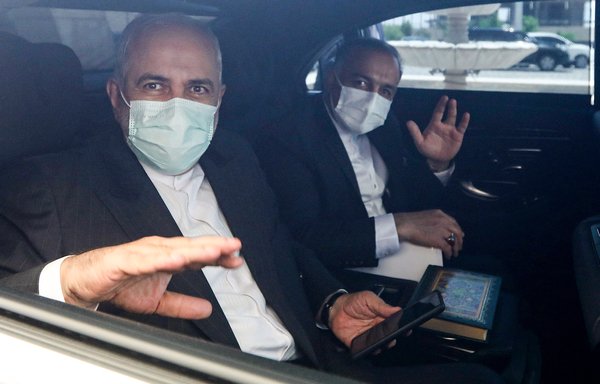 وزير الخارجية الإيراني السابق جواد ظريف (إلى اليسار) يودع نظيره السوري عقب اجتماع عقد في دمشق بتاريخ 12 أيار/مايو. ويقول مراقبون إن إيران في وضع حرج نظرا لتورطها الخارجي في بلدان مثل سوريا. [لؤي بشارة/وكالة الصحافة الفرنسية]