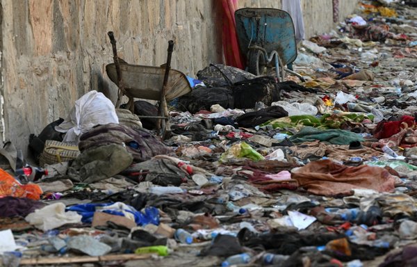 Backpacks and other belongings of Afghans who were waiting for evacuation are seen at the site of the August 26 twin suicide bombs, which killed scores of people, including 13 US troops, at Kabul airport on August 27. [Wakil Kohsar/AFP]