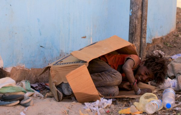 A youth from Yemen's minority group known as 'Muhamasheen', which translates to marginalised, plays inside a discarded cardboard box in Sanaa, on October 24. [Mohammed Huwais/AFP]