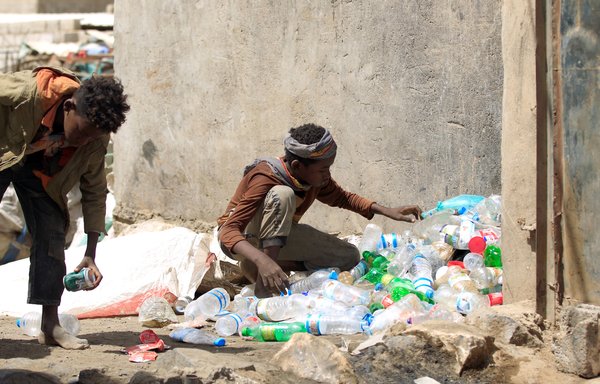 Yemeni boys collect plastic materials from a garbage dump to sell for recycling in Sanaa on March 16, 2019. [Mohammed Huwais/AFP]