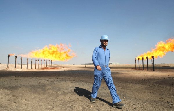 A file picture taken on February 3, 2009, shows an engineer walking at the Barjisiya oil field in Zubair One, southwest of Basra, Iraq. [Essam al-Sudani/AFP]