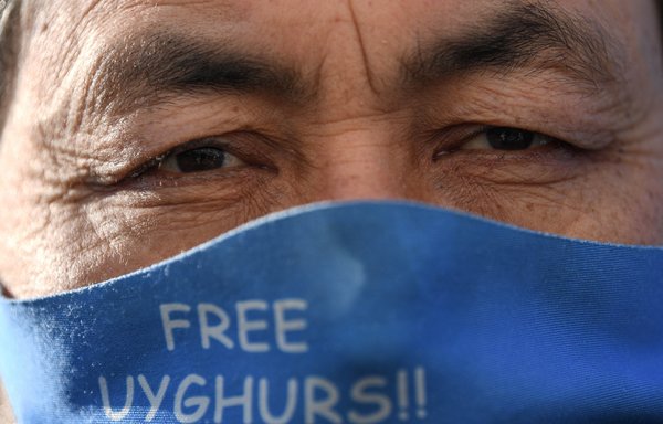 A Uighur wears a face mask displaying a flag of east Turkestan as he asks for news of his relatives during a demonstration in Istanbul February 22. [Ozan Kose/AFP]