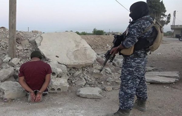 The SDF arrest a suspected terrorist during a raid in August in eastern Deir Ezzor province. [Syrian Democratic Forces]