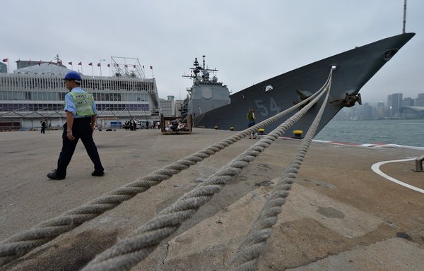 A man walks near the USS Antietam, a Ticonderoga-class guided missile cruiser, in Hong Kong November 12, 2013. [Aaron Tam/AFP]