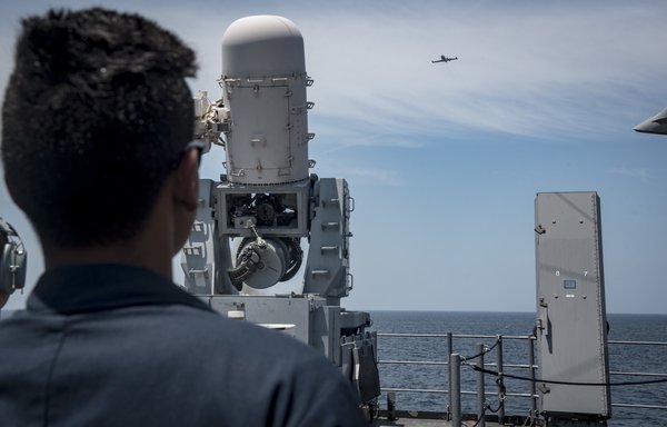 US Navy personnel track a US drone from the deck of a guided-missile cruiser. [US Navy]