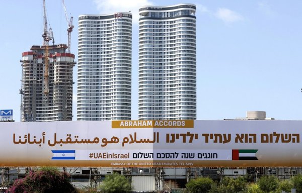 A billboard posted by the UAE embassy marking one year since the signing of the US-brokered normalisation agreements with Israel is seen along the expressway in the Israeli coastal city of Tel Aviv on September 14. The billboard reads in Arabic and Hebrew: 'Peace is the future of our children.' [Jack Guez/AFP]