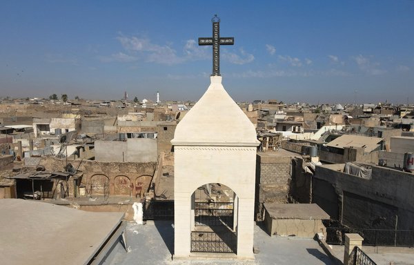 The church bell tower of the Syriac Christian church of Mar Tuma in Mosul, Ninawa province, was inaugurated on September 18 to the cheers of Iraqi Christians, four years after ISIS was driven out of the city. [Zaid al-Obeidi/AFP]