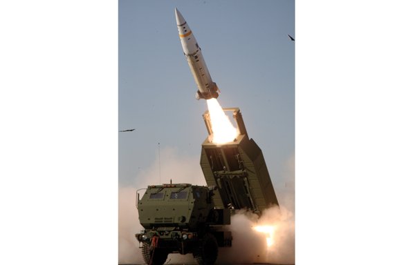 An Army Tactical Missile System missile is fired over the cab of an M142 High Mobility Artillery Rocket System launcher. [US Army]