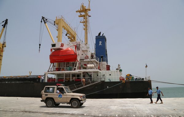 Yemeni coast guards walk past a ship at Salif port in the western Red Sea's al-Hodeidah province following the withdrawal of Iran-backed Houthis on May 13, 2019. [AFP]