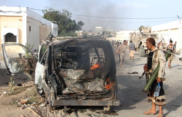 A Yemeni man looks at a burning vehicle following a suicide car bombing in the Lahj provincial capital of Huta, an al-Qaeda bastion, on March 27, 2017. [Saleh al-Obeidi/AFP]