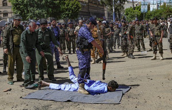 A Houthi militant executes a man in a public square in the Yemeni capital Sanaa on September 18. [Mohammed Huwais/AFP]