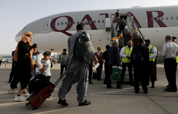 Afghan dual nationals board a Qatar Airways flight at Hamid Karzai International Airport in kabul bound to Doha on September 10. Dual national citizens from Canada, Britain, Germany and France were evacuated from Afghanistan to Qatar. [Marwan Tahtah/Qatari MOFA]