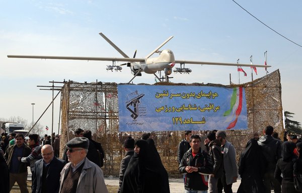 Iranians walk past Iran's Shahed 129 drone displayed in Tehran in February 2016. [Atta Kenare/AFP]