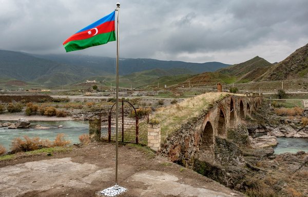 اهتزاز پرچم ملی جمهوری آذربایجان در کنار پل قرون وسطایی خداآفرین در شهر جبرائیل واقع در مرز ایران. این سرزمین‌ها حدود سه دهه تحت تسلط جدایی‌طلبان ارمنستان بود و ۱۹ آذر سال گذشته طی درگیری‌های شدید بر سر منطقه مورد اختلاف ناگورنو-قره‌باغ از نیروهای ارمنستان پس گرفته شد. [استرینگر/خبرگزاری فرانسه]