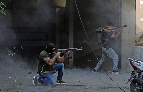 مقاتلون من حزب الله وحركة أمل يصوبون رشاشاتهم من طراز كلاشنيكوف وقاذفات آر بي جي أثناء الاشتباكات في منطقة الطيونة في ضاحية بيروت الجنوبية يوم 14 تشرين الأول/أكتوبر. [إبراهيم عمرو/وكالة الصحافة الفرنسية]