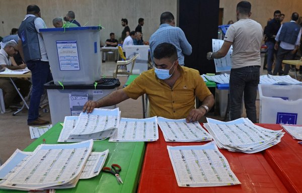 Employees of Iraq's Independent High Electoral Commission conduct a manual count of votes following the parliamentary elections in Baghdad's Green Zone area on October 13. [Ahmed al-Rubaye/AFP]