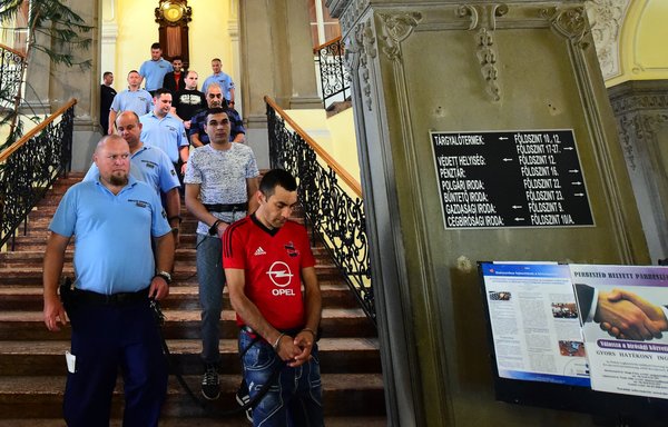 Members of an international smuggler group are pictured at a courthouse in the Hungarian town of Kecskemet on June 21, 2017, during the opening of a trial in connection with the deaths of 71 migrants from Syria, Iraq and Afghanistan found in an abandoned truck in Austria in 2015. [Atilla Kisbenedek/AFP]