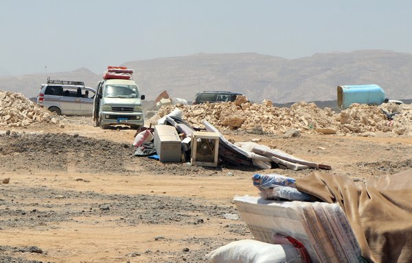 Vehicles are parked next to stacked items and belongings at a displacement camp about 10km outside the city of Marib on March 28, as camp residents prepare to flee the area because of its proximity to battles between the Houthis and Yemeni forces. [STR/AFP]
