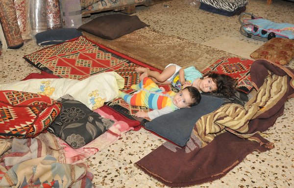 Abdel Wahab Shami's family lives in a room on the roof of an old building with no furniture, where his two children, one of whom is ill, sleep on the floor. [Ziad Hatem]