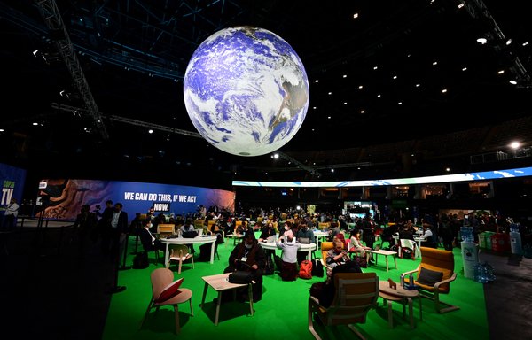 Delegates sit in the Action Zone as they attend the third day of the COP26 UN Climate Summit in Glasgow on November 3. [Paul Ellis/AFP]