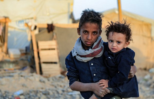 Yemeni children stand outside a tent at a camp for internally displaced persons on the outskirts of Marib on October 29. [AFP]