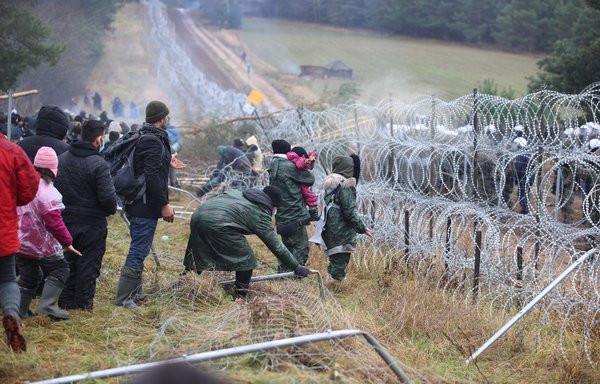 A picture taken on November 8 shows migrants at the Belarusian-Polish border in the Grodno region. Poland on November 8 said hundreds of migrants in Belarus were descending on its border aiming to force their way into the EU member in what NATO slammed as a deliberate tactic by Minsk. [Leonid Shcheglov/BELTA/AFP]