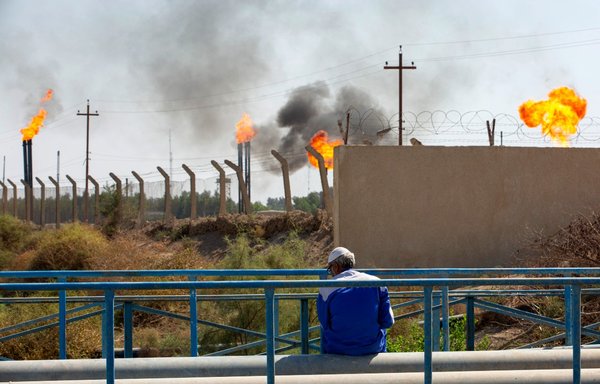 در روز ۳ آبان، مردی در میدان نفتی نهر بن عمر در استان بصره، عراق در میان مشعل‌ هایی نشسته است که گاز اضافی این میدان نفتی را می سوزانند. بصره حدود ۷۰ درصد از نفت خام کشور را تولید می کند، با این حال این استان به ویژه بر اثر مشکلات فروانی که عراق به آنها دچار شده است، شدیداً آسیب دیده است. [حسین فالح/ خبرگزاری فرانسه]