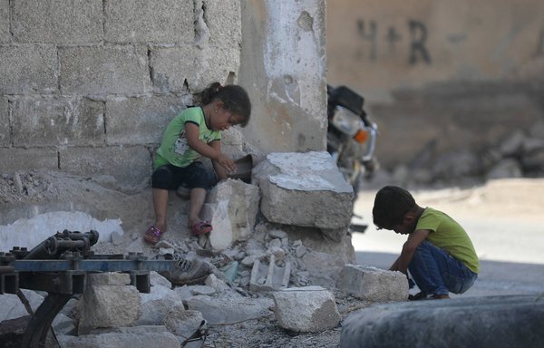 کودکان سوری در میان خرابه های ساختمان های ویران شده بر اثر جنگ در مورک، شهری در حومه شمالی استان حماه، بازی می کنند. [عمر حاج کادور/ خبرگزاری فرانسه]