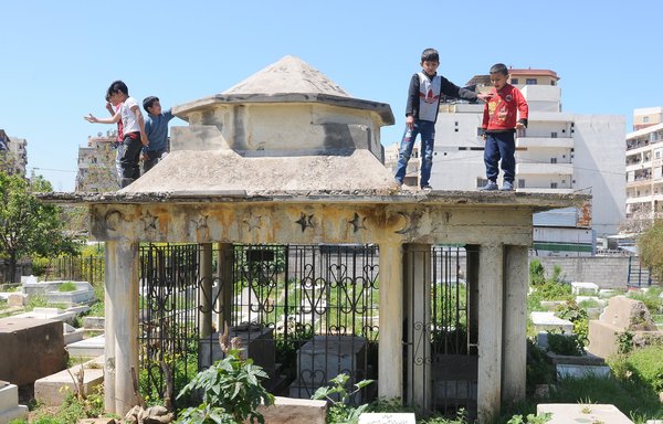 أطفال سوريون في سن الدراسة يلعبون في مقبرة بأحد أحياء طرابلس في خريف 2021 بدل الالتحاق بالمدرسة. [زياد حاتم]