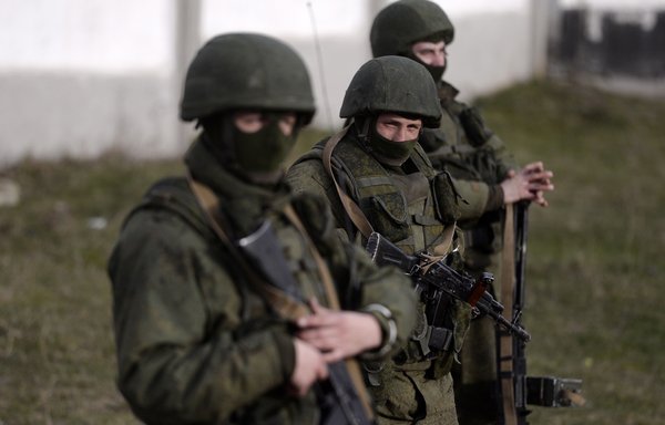 Unidentified men stand guard outside a Ukrainian military base in Perevalnoye, Crimea, March 16, 2014. Ukraine was the "birthplace" of the Wagner Group, a group of mercenaries who work at the behest of Russian President Vladimir Putin. [Dimitar Dilkoff/AFP]