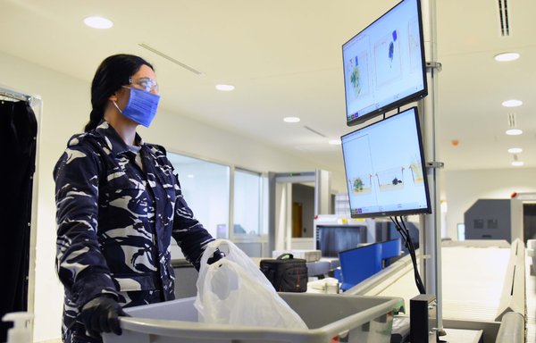 A member of Lebanon's Internal Security Forces wears a protective mask against COVID-19 as she inspects items on a security belt. [ISF Public Relations Division]